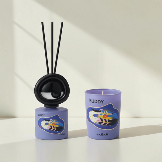 Good Bounty WEKÜKÜ Buddy home fragrance set featuring a purple candle and diffuser with whimsical Big Eye illustrations.