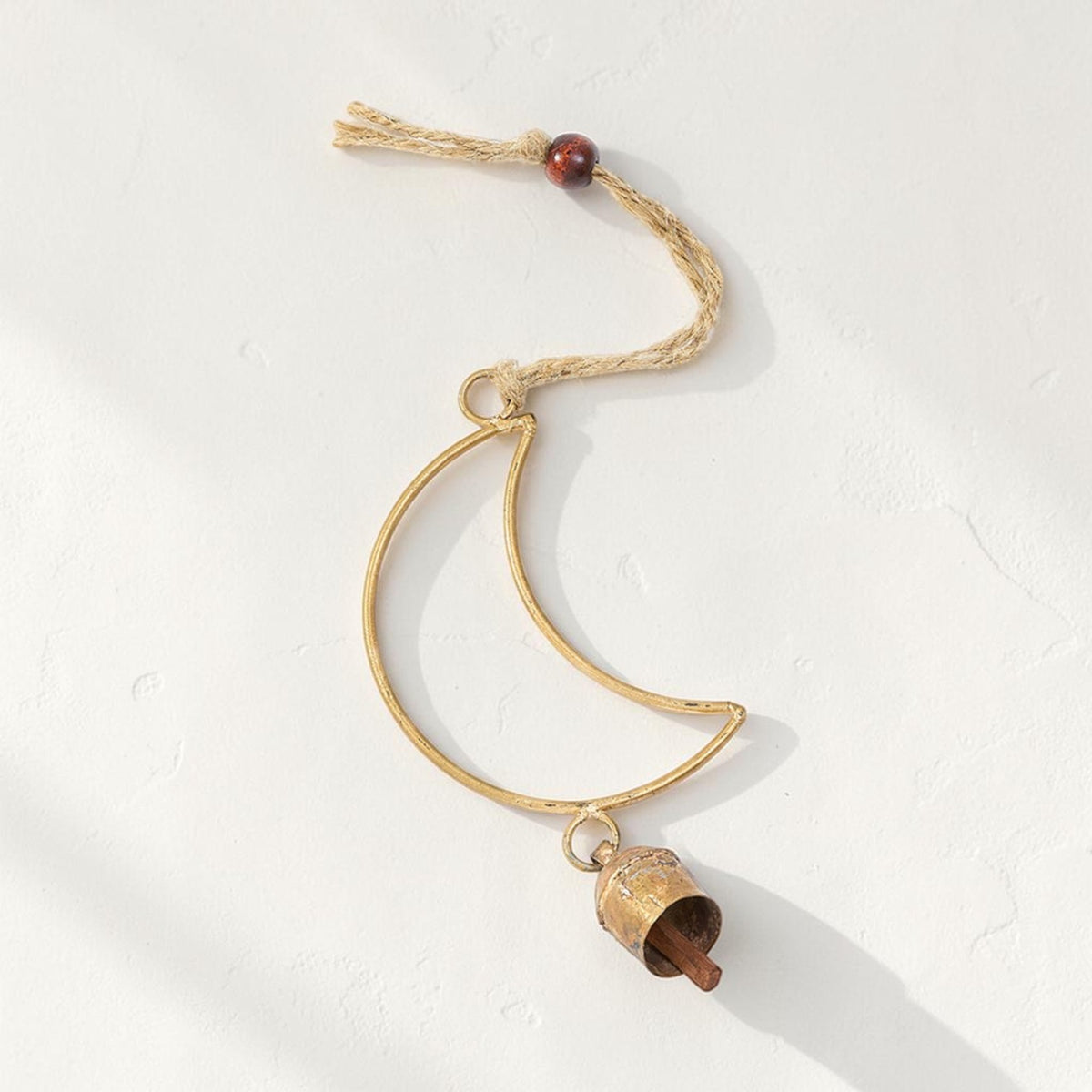 Good Bounty handcrafted crescent moon wind chime with a brass bell, wooden bead, and jute hanging loop.