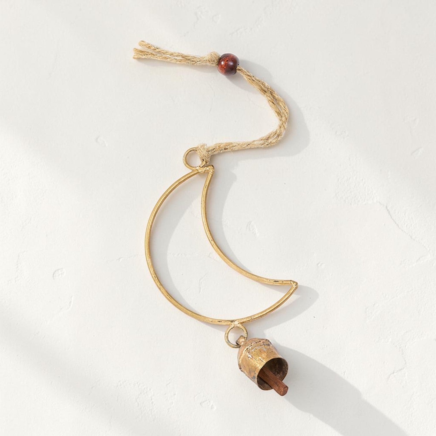 Good Bounty handcrafted crescent moon wind chime with a brass bell, wooden bead, and jute hanging loop.